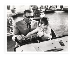 Movie still of Ray Charles sitting in a bumper car with child