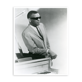 Ray Charles standing and leaning on a piano