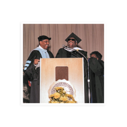Ray Charles in a graduation cap and gown standing at a podium for Wilberforce University