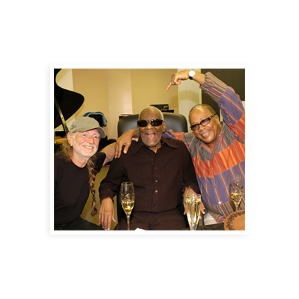 Ray Charles having champagne with Willie Nelson and Quincy Jones